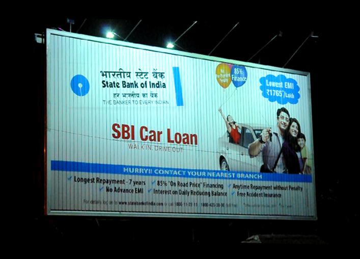 Digital LED billboard with purple and teal graphics on corner building